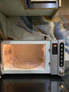 eine Mikrowelle mit offener Tür auf einem Tisch in der Unterkunft Modern 1BR Apartment in Multan in Multan