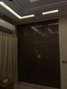 ein Zimmer mit schwarzen Schränken und einem Duschvorhang in der Unterkunft Modern 1BR Apartment in Multan in Multan