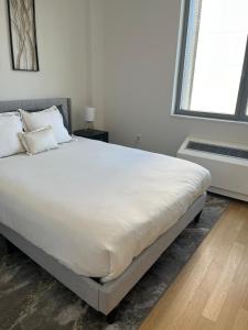 un letto grande in una camera da letto con una grande finestra di Time Square Condos a New York