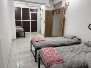a room with two beds in a room at Mahayaatri Niwas in Kolhapur