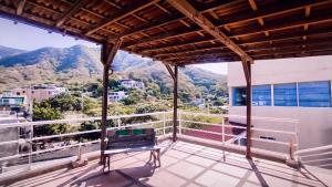 ein Balkon mit einer Bank und Bergen im Hintergrund in der Unterkunft Casa Luna Hotel in Taganga