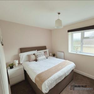 een slaapkamer met een groot bed en een raam bij Modern & Spacious Flat with Balcony Views in Stroud