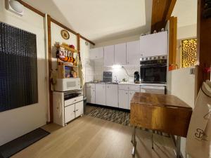 eine Küche mit weißen Schränken und weißen Geräten in der Unterkunft Vaste appartement de montagne in Métabief