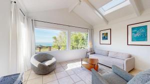 een woonkamer met een bank en een groot raam bij Perched on the Bluff - Casita in Mendocino