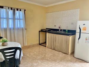 una cucina con frigorifero bianco, tavolo, tavolo e tavolo e tavolo di Hostal las Margaritas a Salta