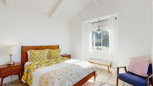 een slaapkamer met een bed, een stoel en een raam bij Perched on the Bluff - Casita in Mendocino