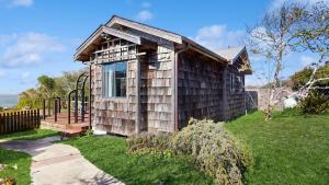 een klein houten huisje met een speeltuin in een tuin bij Perched on the Bluff - Casita in Mendocino