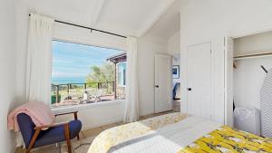 een slaapkamer met een bed en een groot raam bij Perched on the Bluff - Casita in Mendocino +10 foto's