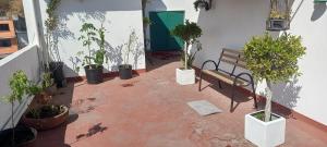 a patio with a bench and potted plants on it at Terraza Amecameca in Amecameca de Juárez