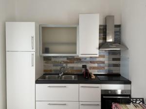 a kitchen with white cabinets and a sink at Amarvi' in Monopoli
