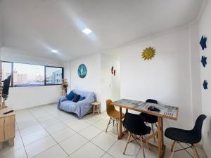 a living room with a table and chairs and a couch at Apê aconchegante perto do mar in Cabedelo