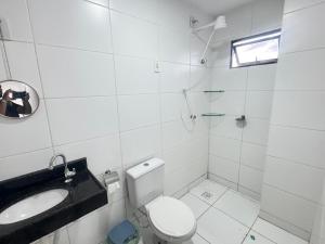 a white bathroom with a sink and a toilet at Apê aconchegante perto do mar in Cabedelo +12 photos