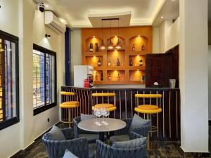 Un bar con sillas y una mesa en una habitación. en Logements Majeo, en Kribi