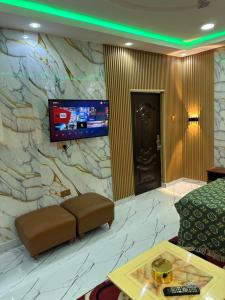 Camera con parete in pietra, divano e TV. di Property Pioneers a Accra