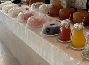 Ein Tisch, der mit Plastikbehältern für Speisen und Getränke bedeckt ist in der Unterkunft Lençóis Barreirinhas in Barreirinhas