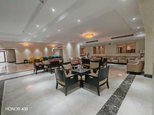a lobby with chairs and tables and a bar at فندق مواسم الاحسان توصيل مجانى للحرم in Al ‘Azīzīyah