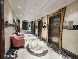 a lobby of a hotel with a chair and a staircase at فندق مواسم الاحسان توصيل مجانى للحرم in Al ‘Azīzīyah