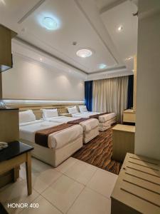 a hotel room with four beds in a room at فندق مواسم الاحسان توصيل مجانى للحرم in Al ‘Azīzīyah +51 photos