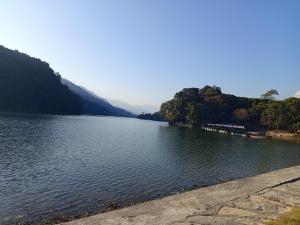 una vista di un lago con le montagne sullo sfondo di Annapurna Himdrishya Pokhara a Pokhara