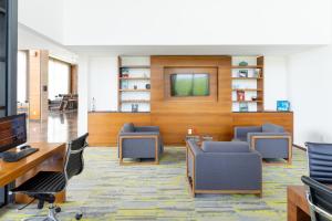 un ufficio con sedie e tv a muro di Fiesta Inn Mérida Altabrisa a Mérida