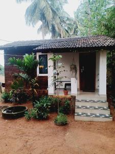 a small house with a porch and a door at Gokarna Royal Cottage in Gokarna
