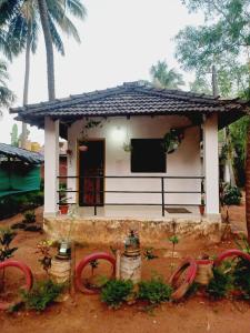 a small house with a porch and some plants at Gokarna Royal Cottage in Gokarna +5 photos