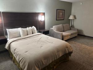 une chambre d'hôtel avec un lit et un canapé dans l'établissement Brookings Inn, à Brookings