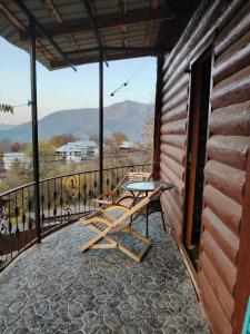 a patio with a table and chairs on a balcony at Green Nest Tba in Itʼkhvisi