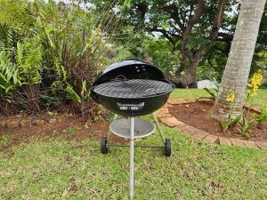 a charcoal grill on a stand in the grass at Ballito garden flatlet, 5 mins to beach in Ballito