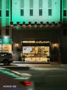 a car driving past a store window at night at فندق مواسم الاحسان توصيل مجانى للحرم in Al ‘Azīzīyah