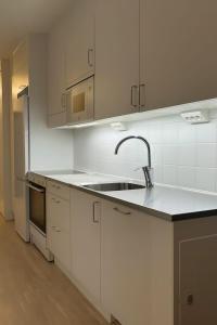 eine Küche mit weißen Schränken und einer Spüle in der Unterkunft Fresh Trendy apartment in Stockholm