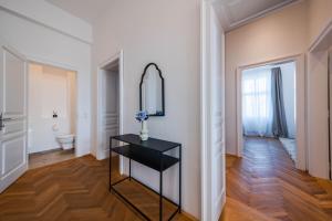 een witte kamer met een spiegel en een zwarte tafel bij Smile Apartments am Stadtpark in Krems an der Donau