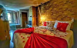 een groot bed met rode kussens en een bakstenen muur bij Chalés Colline Verte in Monte Verde