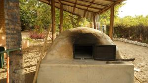 an outdoor oven with a cat sleeping on the table at Campement solidaire Nioko Bokk in Abémé