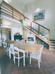 une salle à manger avec une table en bois et des chaises blanches dans l'établissement Villa Oliviana, à Montecarlo