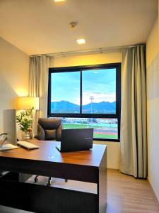 ein Büro mit einem Schreibtisch mit einem Laptop und einem großen Fenster in der Unterkunft Work and Travel in Kathu