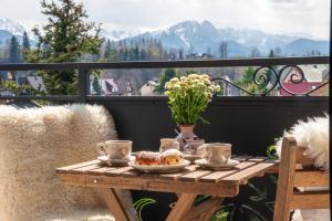 un tavolo su un balcone con vista sulle montagne di Pensjonat Litworówka Wellness&SPA a Poronin