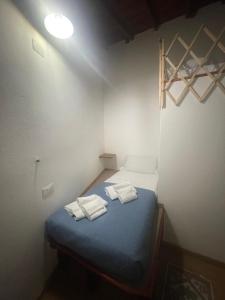 een kleine kamer met een bed met handdoeken erop bij Luxar Suites & Apartments in Assemini