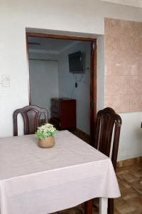 un tavolo con un vaso di fiori sopra di Hostal las Margaritas a Salta