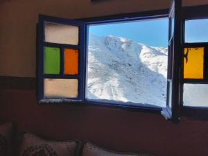 a window with a view of a snow covered mountain at riad atlas imnane in Imlil