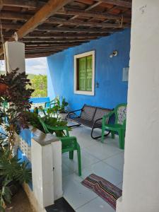 eine Veranda mit blauen Wänden und grünen Stühlen in der Unterkunft Pousada Tereza in Piranhas