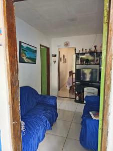 ein Wohnzimmer mit 2 blauen Sofas und einem TV in der Unterkunft Pousada Tereza in Piranhas