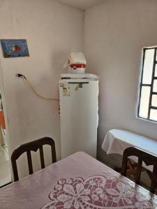eine Küche mit einem Kühlschrank sowie einem Tisch und Stühlen in der Unterkunft Pousada Tereza in Piranhas