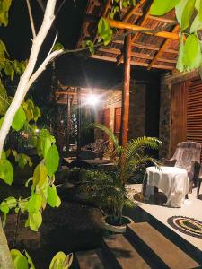 an outdoor patio with a table and chairs and trees at Clay House in Udawalawe