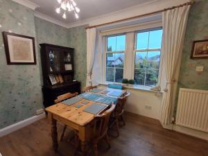 een eetkamer met een houten tafel en een raam bij Andreu Cottage in Callander
