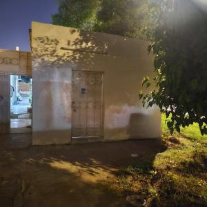 un bâtiment blanc avec une porte sur son côté dans l'établissement Kady and Kojic Hideout, à Al-Aïn