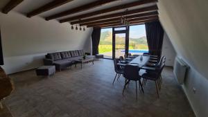 ein Esszimmer mit Tisch und Stühlen und einer Couch in der Unterkunft Cabana BDL in Izvoarele
