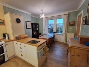 een keuken met een tafel en een eetkamer bij Andreu Cottage in Callander