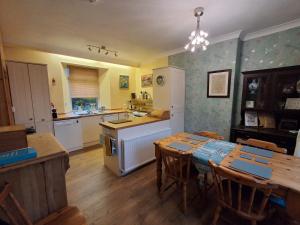 een keuken met een tafel en een keuken met een fornuis bij Andreu Cottage in Callander