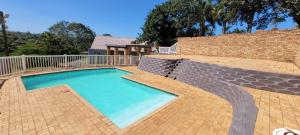 a swimming pool with a bench next to a brick wall at Unit51 MarinaGlen Holiday Resort in Marina Beach